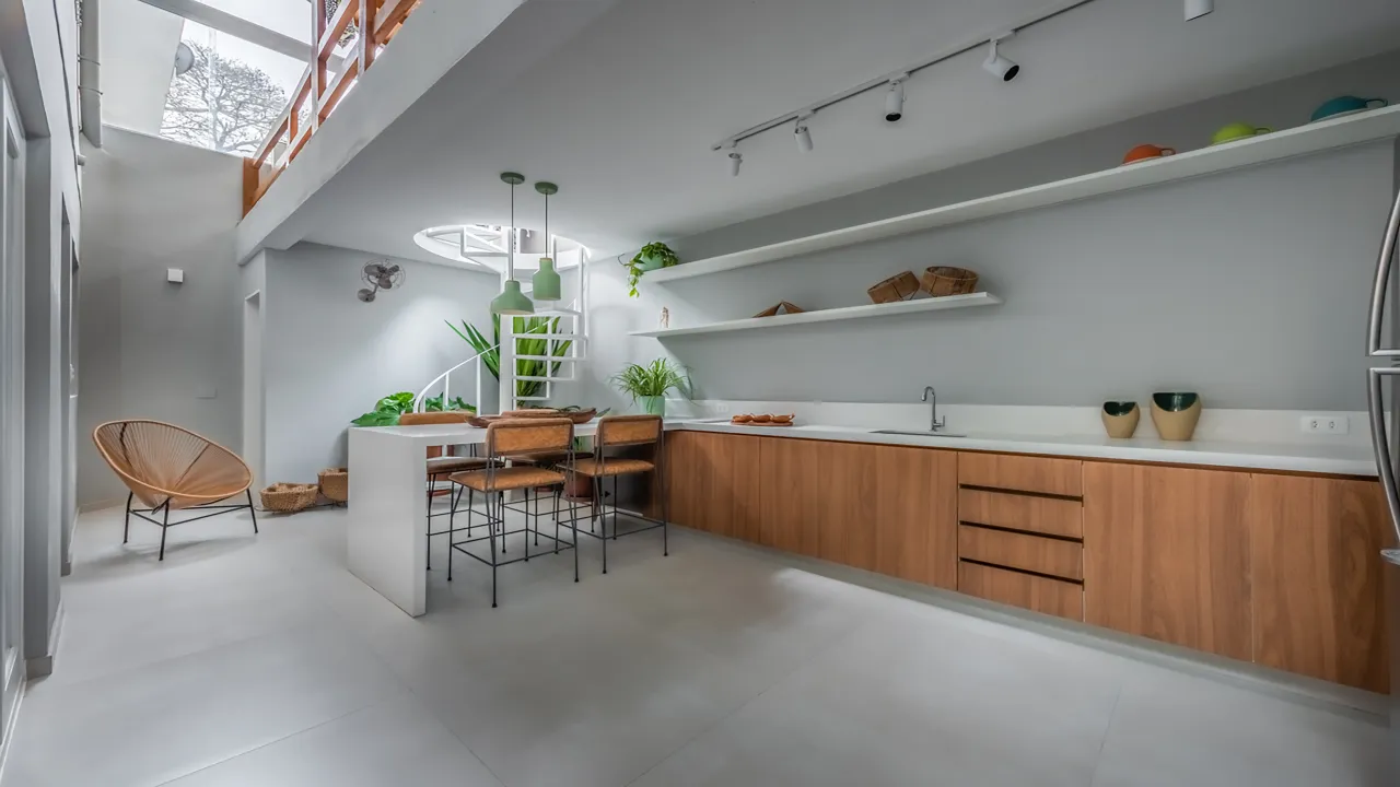 Cozinha integrada da Casa Praça com marcenaria em madeira e iluminação de trilho