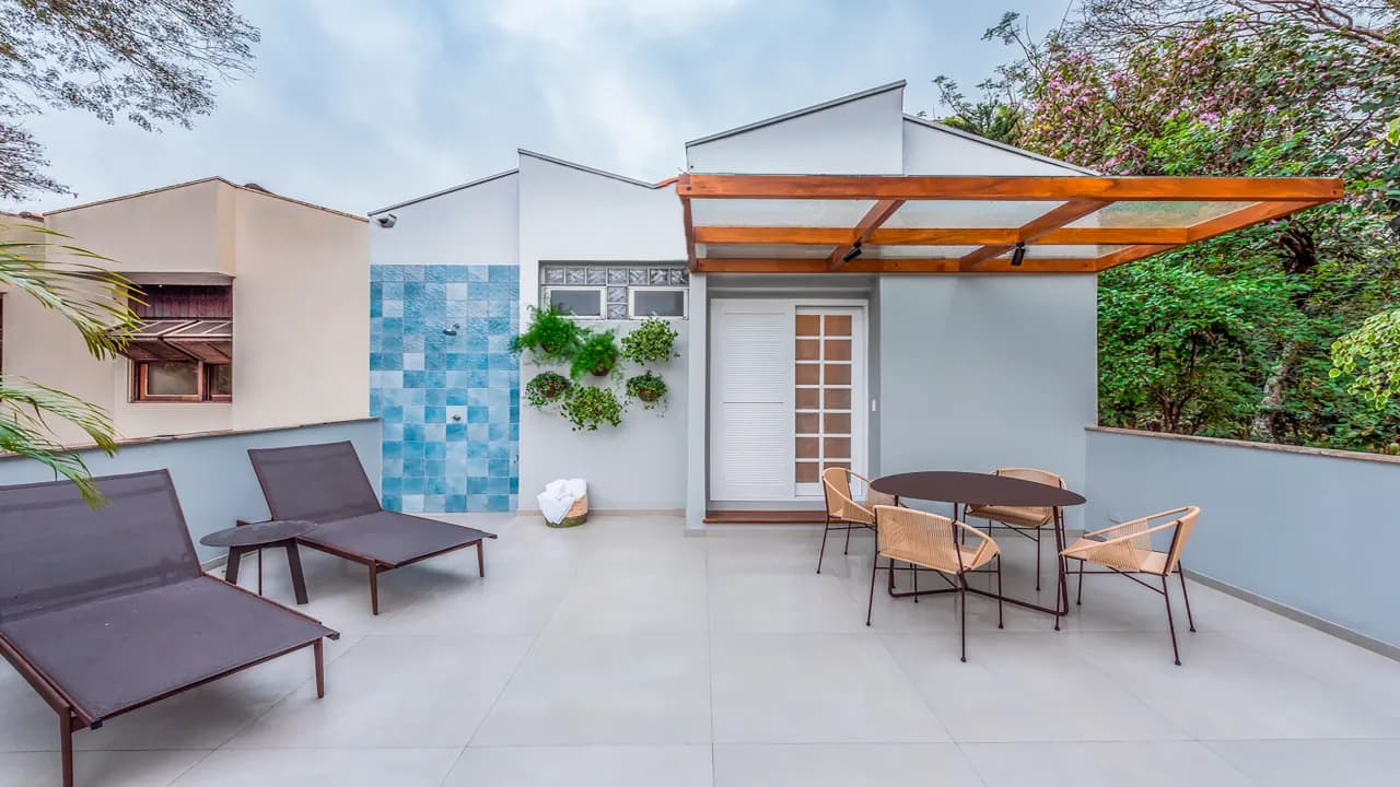 Terraço externo da Casa Praça com pergolado de madeira