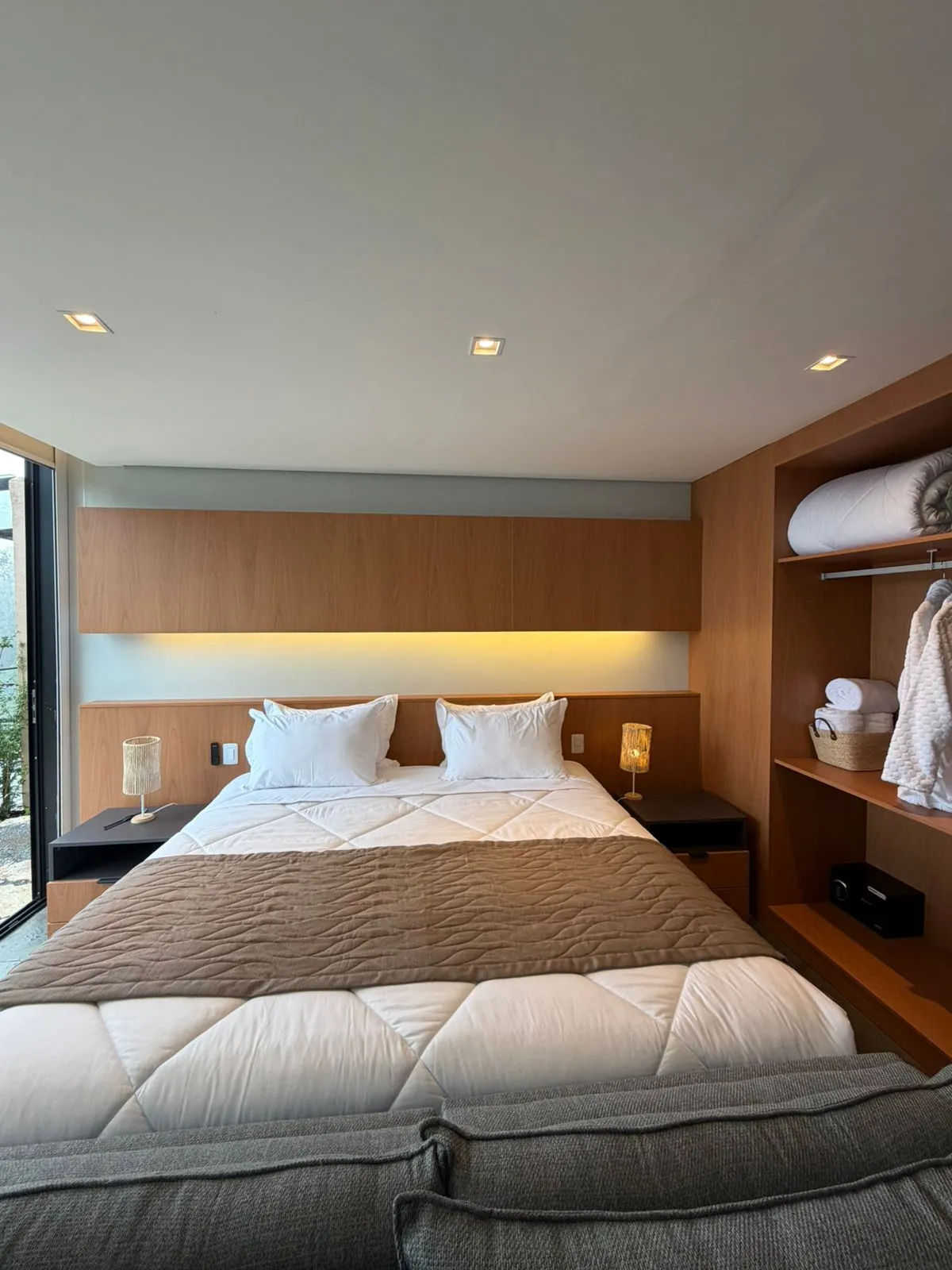 Quarto da Vila Don Patto com marcenaria em madeira e iluminação embutida